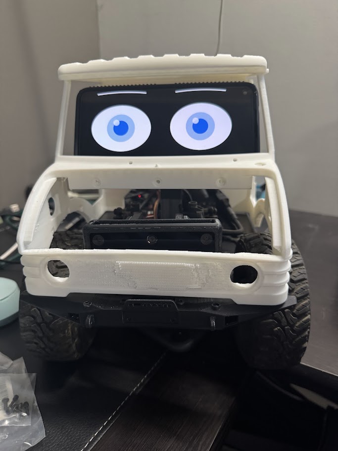 The Kilo rover head-on, showing the stereo camera module mounted centrally behind the bumper, below the phone head's eyes
