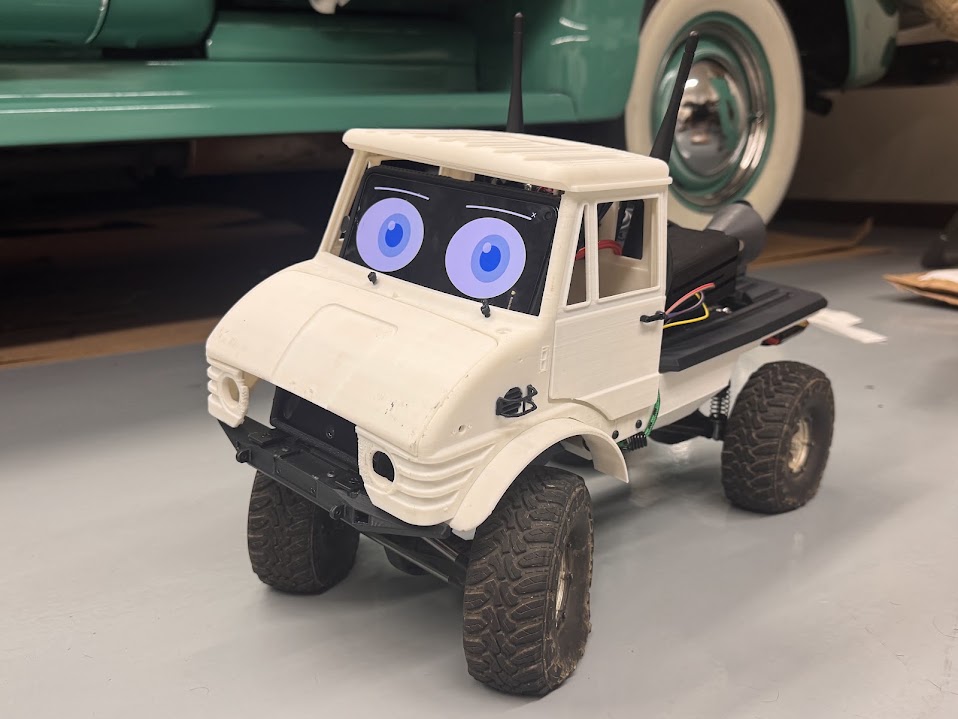 Kilo: a small 3D-printed off-road truck with a phone as its head, showing large blue animated eyes